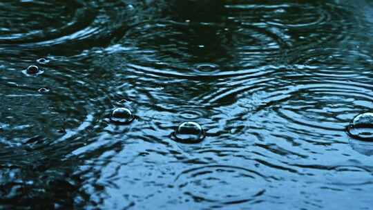 阴沉天气下雨天雨滴落下冒泡特写