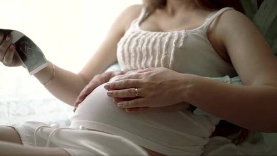 丈夫抚摸妻子怀孕的肚子视频素材模板下载
