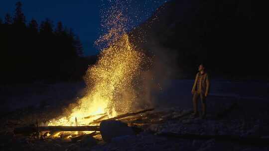 夜晚男生站在燃烧的篝火旁视频素材模板下载