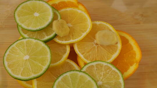 落在玻璃碗里的柠檬、橘子和酸橙上的姜片。慢动作。视频素材模板下载