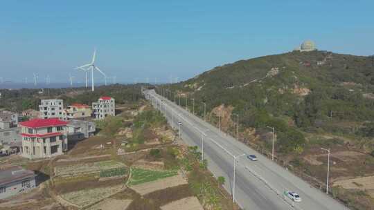 乡村公路旁的风力发电机和住宅