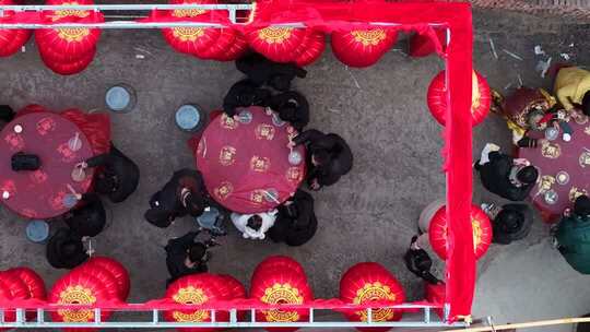 红灯笼下人们围桌相聚场景