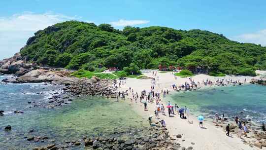 海南三亚蜈支洲岛海岸线白沙滩上大量游客