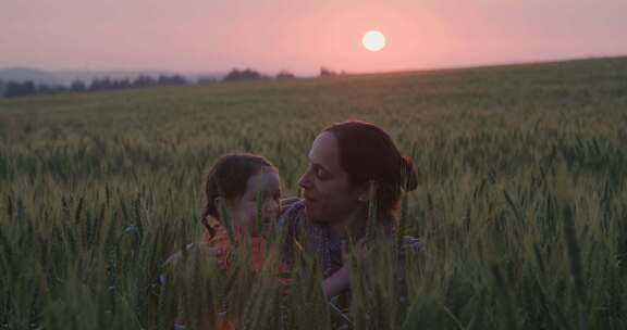 日落时分，母亲在田野里亲吻她的小女孩