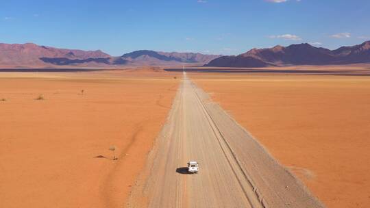 航拍行驶在无人沙漠道路的车辆