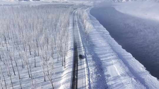 汽车行驶在冬天下雪雾凇的道路上