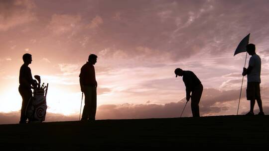 夕阳西下一群人打高尔夫球剪影