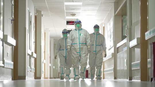 穿着防护服的医护人员行走在隔离病房