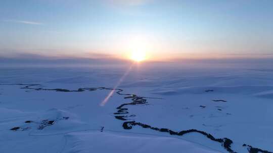 辽阔雪原蜿蜒冰封河流唯美夕阳