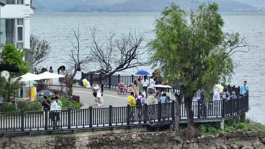 航拍云南大理洱海旅游人群游客雨天打伞视频素材模板下载