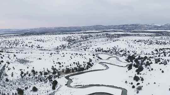 河流蜿蜒穿过积雪覆盖的冬季平原和道路天线