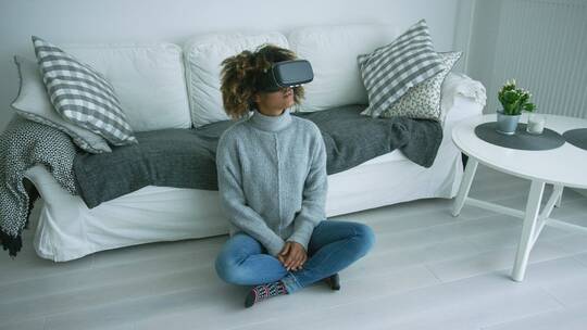 戴着VR眼镜的女人坐在地板上
