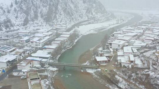 航拍川藏线上的藏主村庄大雪纷飞视频素材模板下载