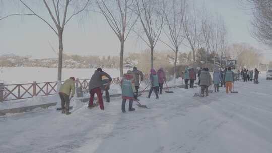 装载机铲雪作业，工作人员现场查看