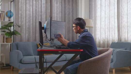 亚洲男孩程序员在创建软件工程师开发应用程序时使用智能手机视频素材模板下载