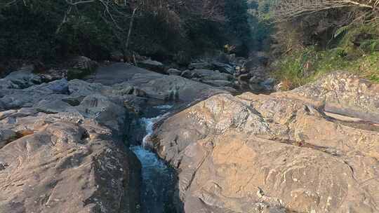 阳光下山涧河床上的沟壑溪流