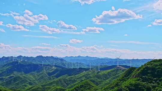 夏季绿色高山蓝天白云与风力发电机组