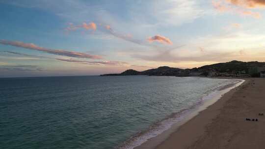 日落时分的海滩景象反射着夕阳的金色光芒