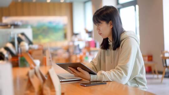 年轻女子在咖啡店使用平板电脑上网视频素材模板下载