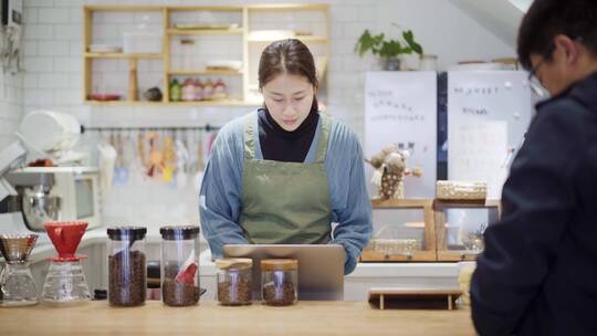 年轻女烘培店长在吧台服务顾客视频素材模板下载