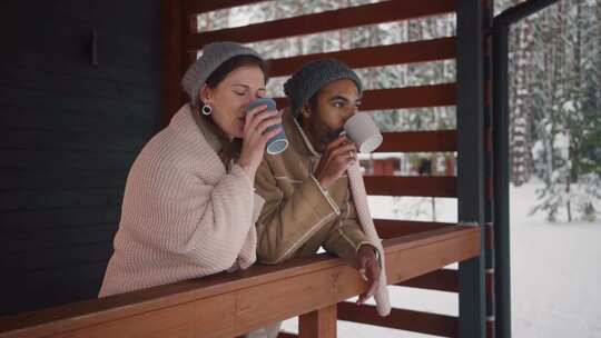 特写情侣在白雪皑皑的森林里赏雪喝咖啡
