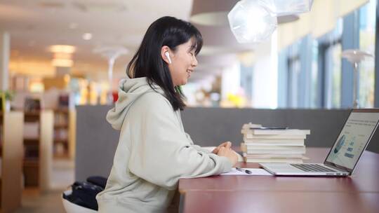 年轻女子在图书馆使用笔记本电脑上网