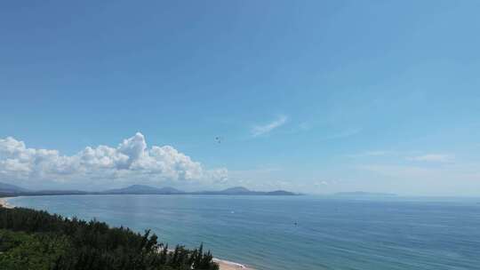 航拍三亚海棠湾蓝天白云动力伞直升机海岸线