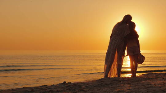 黄昏母女在海边欣赏日落