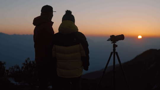 N男女在山顶拍日出夕阳