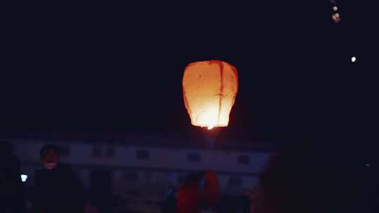 夜晚年轻人放孔明灯