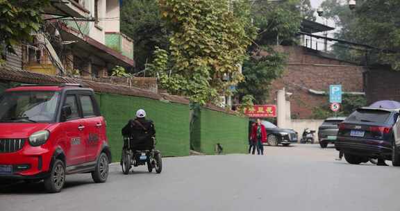 残疾人乘着电动轮椅行驶在拥挤的街道上