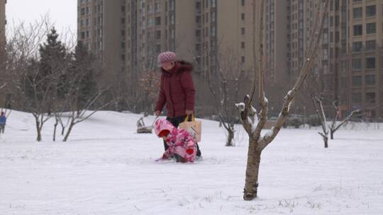 社区小区下雪奶奶陪孙女玩雪
