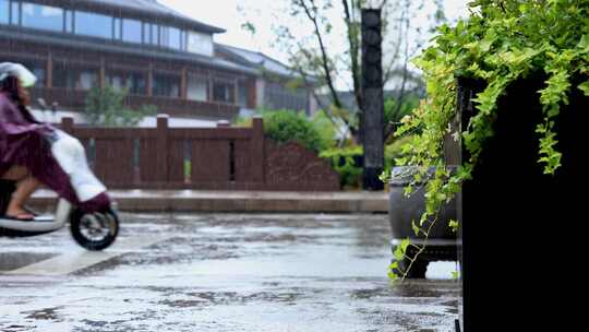 下雨中披着雨衣的骑电瓶车升格