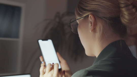 年轻女商人在办公桌上用智能手机浏览网络视频素材模板下载