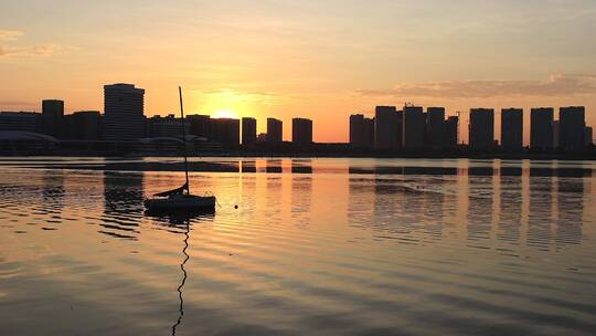 快镜头拍摄冬季厦门海湾日出映照帆船和建筑