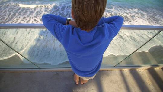 男孩在海岸上看海景