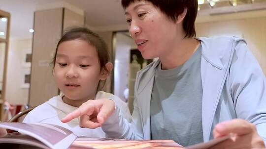 在餐厅翻看菜单点菜的中国母女视频素材模板下载