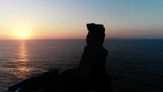 日落时海中岩石的形成