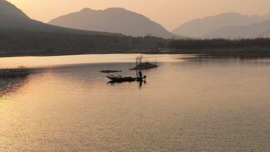 夕阳下湖面小船与人物剪影