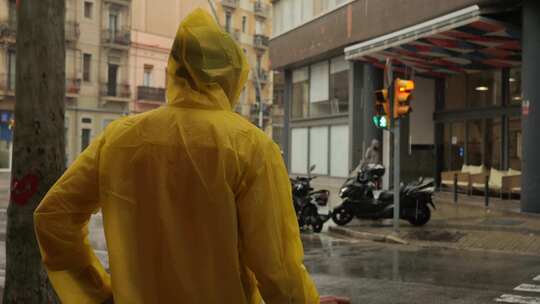 雨中欧洲城市路灯上带伞和雨衣的商人游客