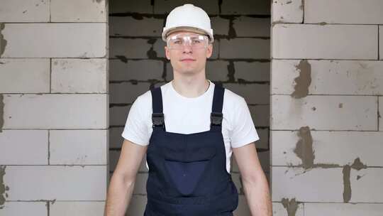 一个年轻的男性建筑工人在一个有维修工作的房间里拿着刷子和水桶
