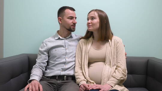 孕妇和她的丈夫坐在沙发上聊天