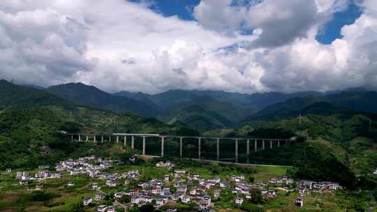 航拍山谷隧道中驶出的高铁列车