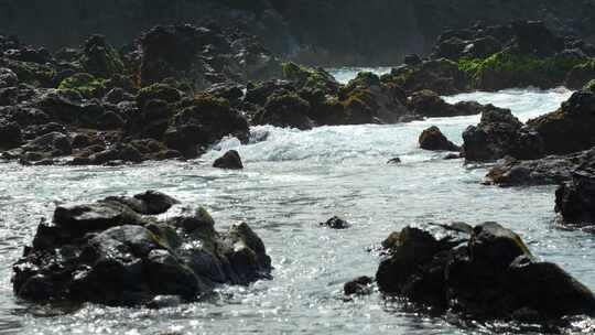 岩石上溢出的水冲向大海，静态特写慢动作