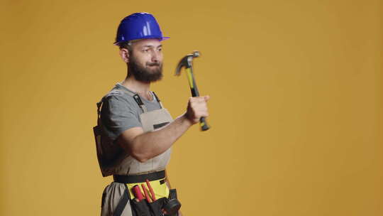 建筑工人使用手动锤子敲打墙上的钉子视频素材模板下载