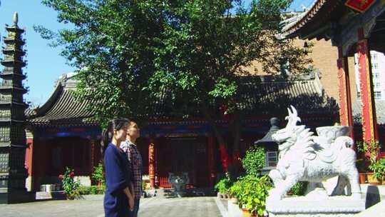 僧人引领香客进入寺院大殿