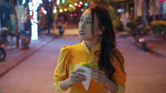 慢动作跟随年轻越南妇女穿着传统服装在晚上