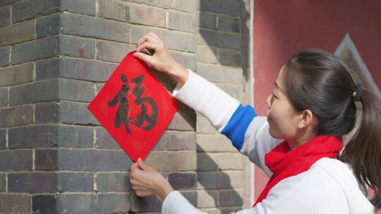 亚洲中国人女性女人过年贴春联贴福字