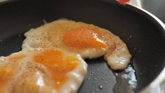 人让蛋黄在煎锅上倒出烹饪鸡蛋