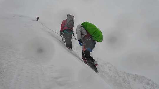 风雪中攀登四川贡嘎山区贡巴峰的登山者